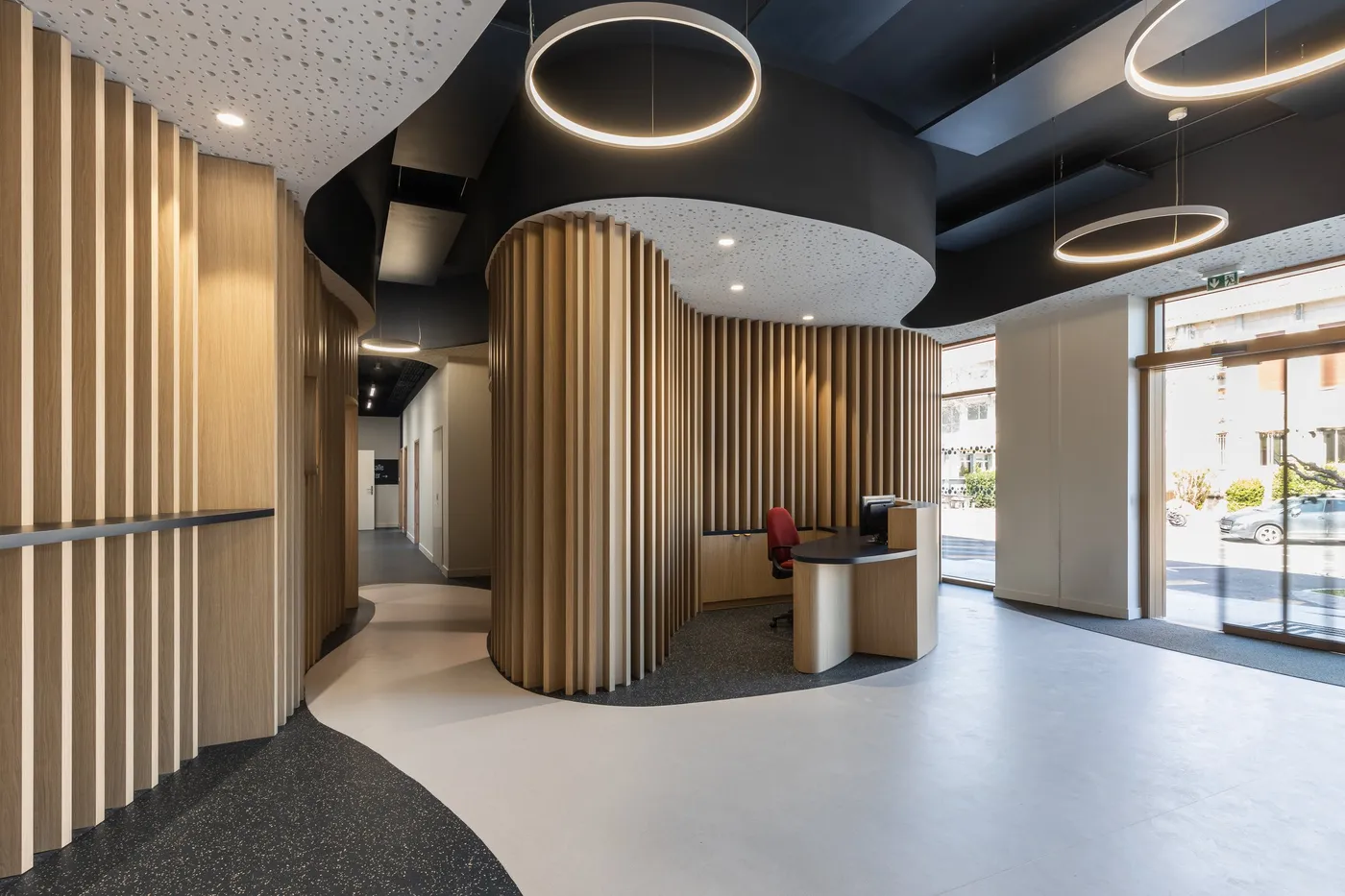 Hall à lames de bois courbes menant à la banque d'accueil