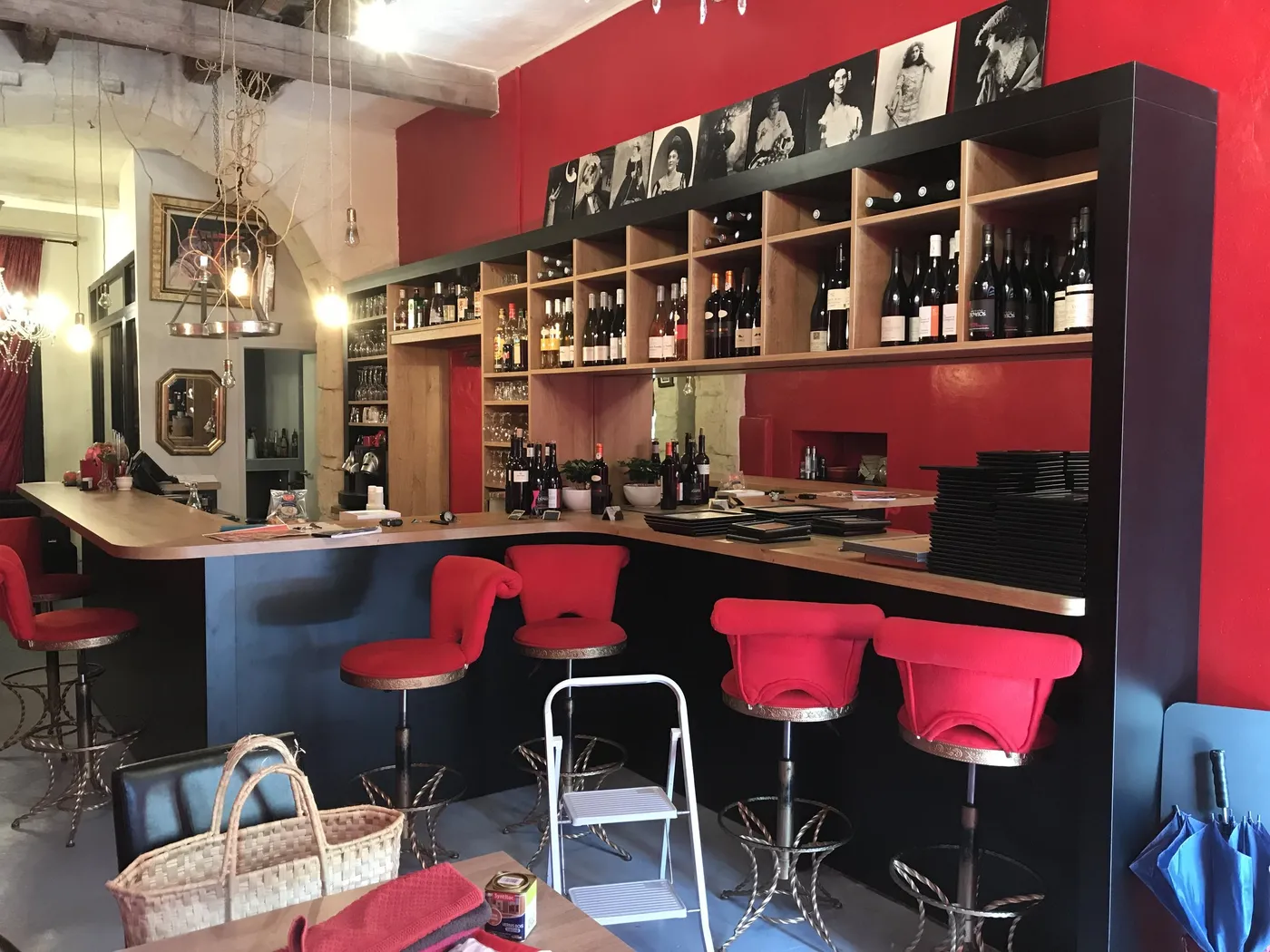 Comptoir courbe en chêne et noir, arrière-bar à niches sur mur rouge