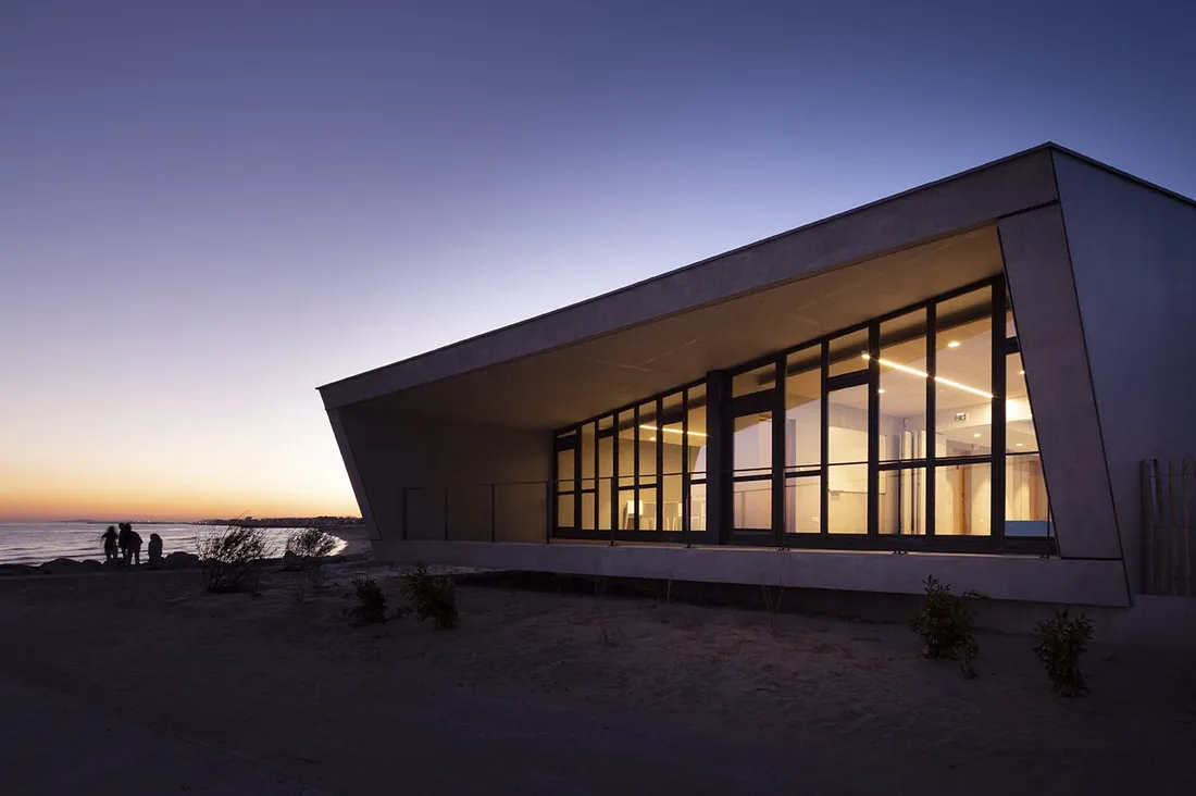 Le bâtiment au crépuscule, vitrages éclairés