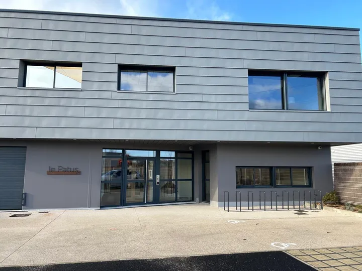 Bâtiment tertiaire Le Patus : fenêtres en bandeau et ensemble d'entrée en aluminium anthracite
