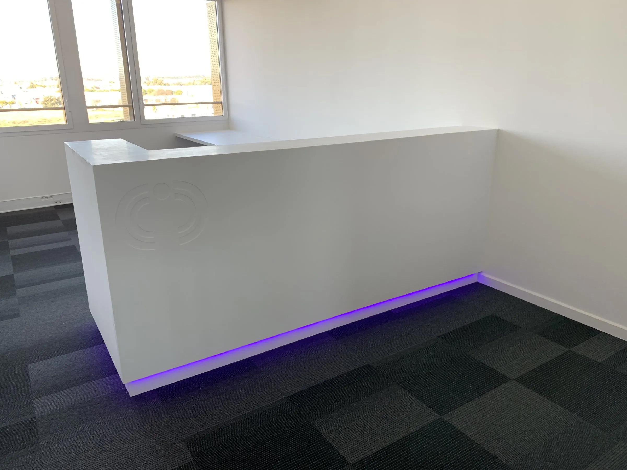 Banque d'accueil blanche à liseré lumineux