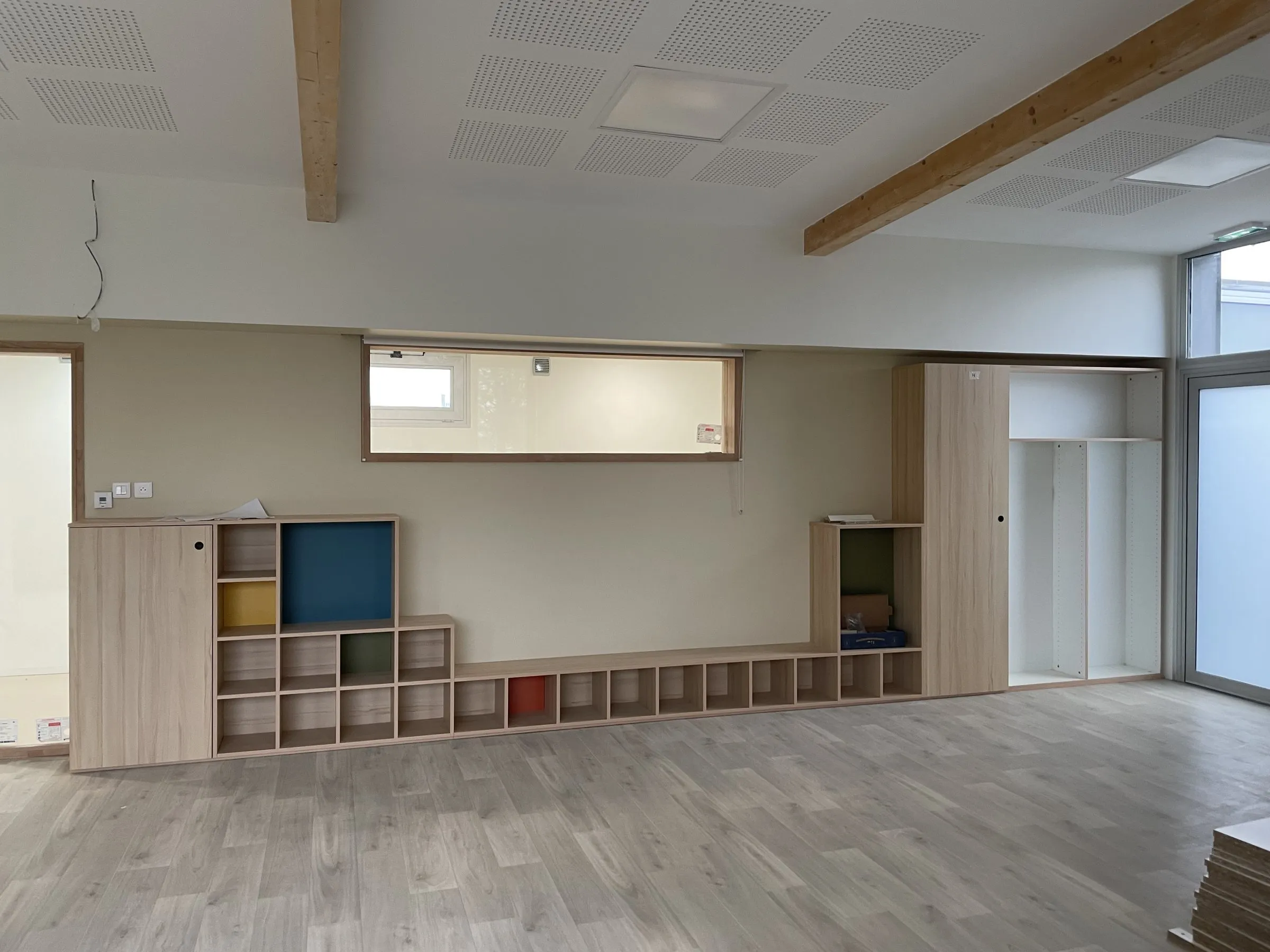 Meuble bas à cases colorées et placards en bois clair