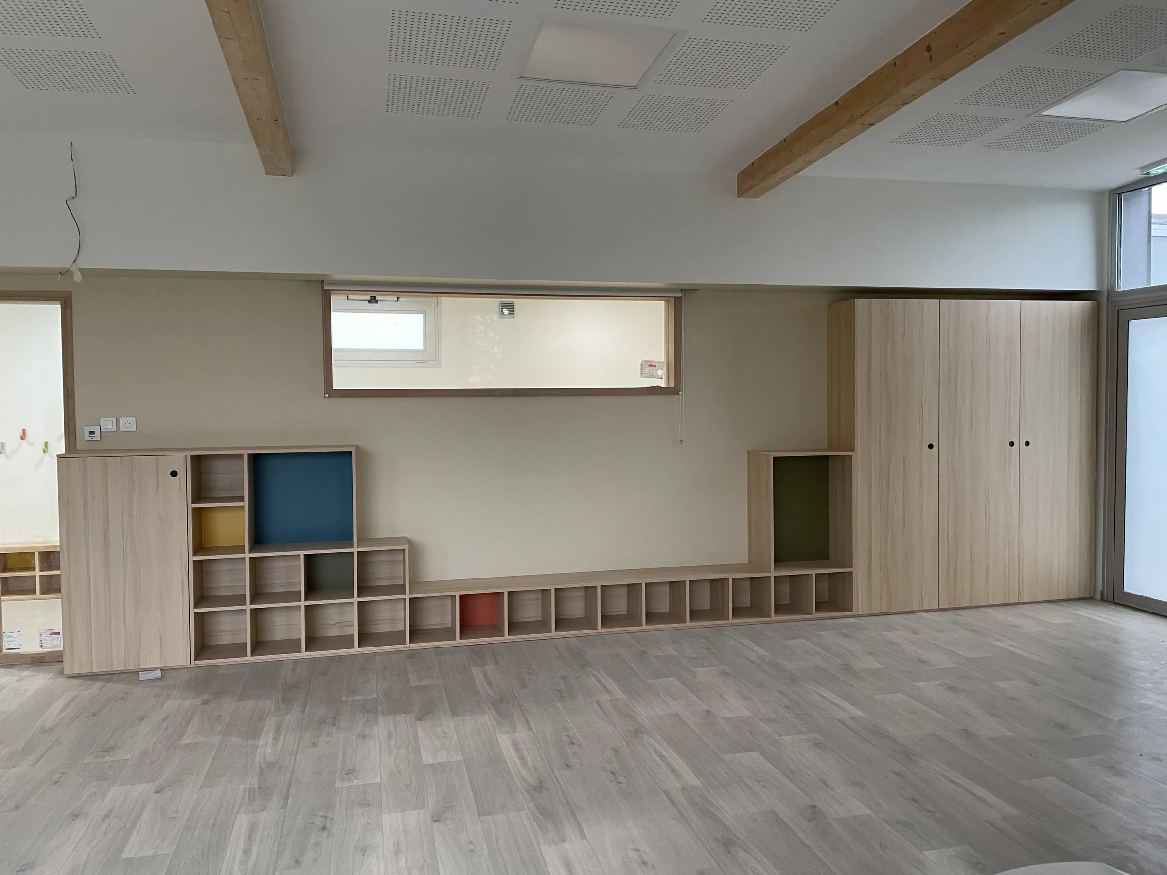 Meuble bas à cases colorées, vue de la salle