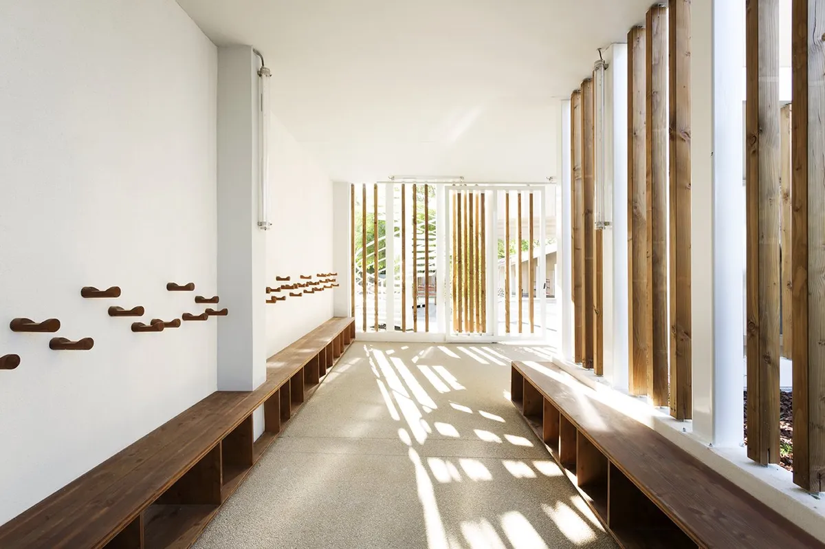Coursive avec lames de bois verticales et banc