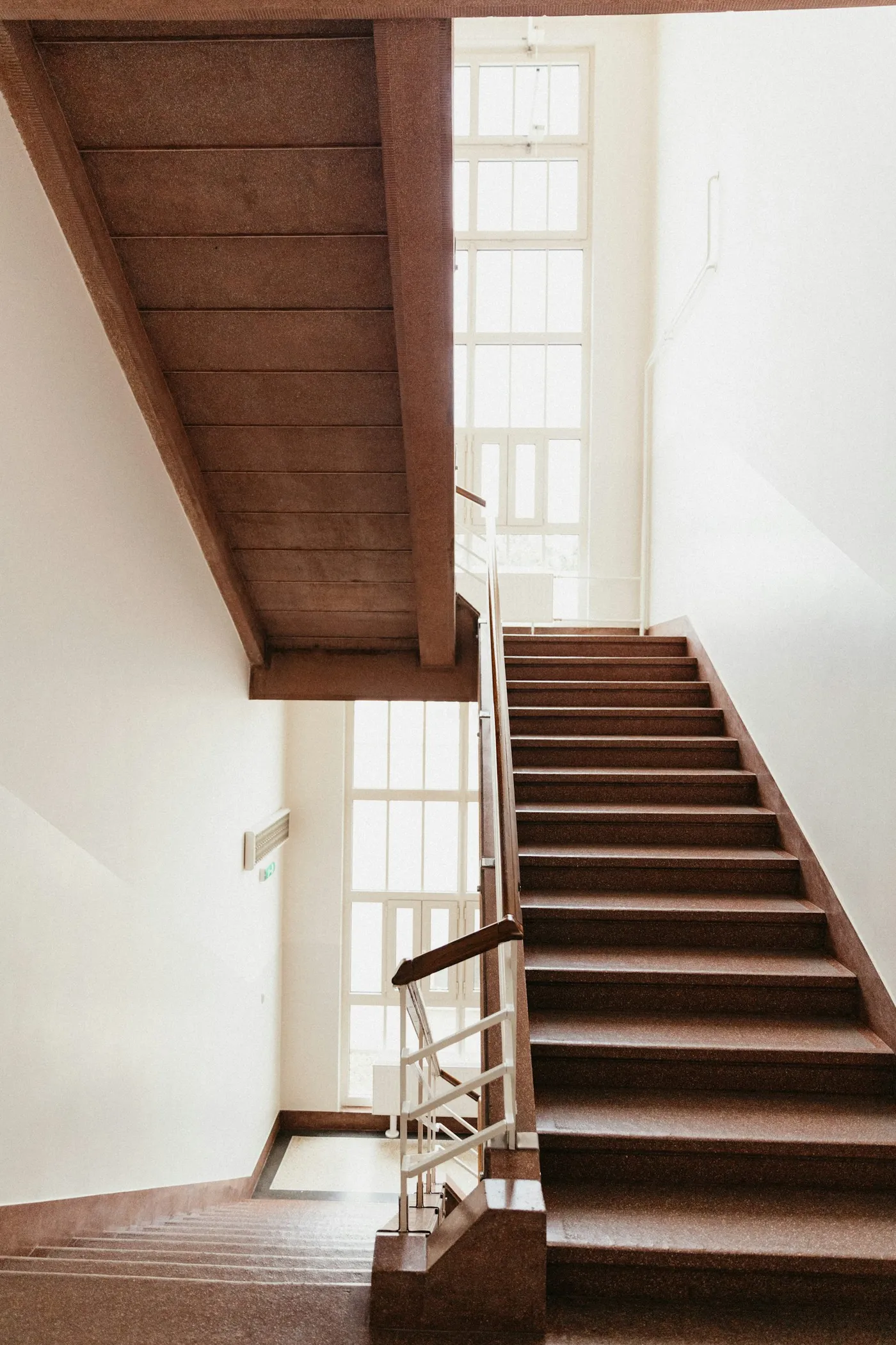 Escalier droit en bois dans une cage d'escalier claire