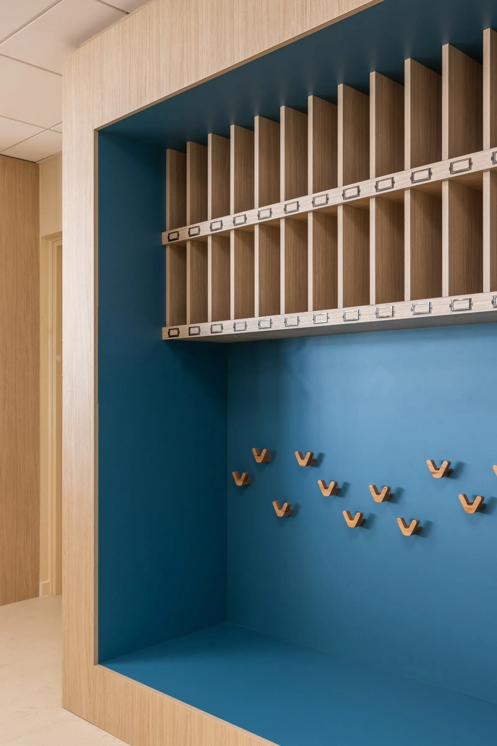 Niche bleue avec casiers à lames et patères en forme d'oiseaux