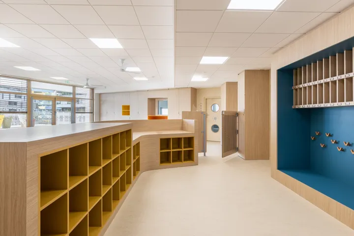 Casiers cintrés ocre et niche bleue à patères dans une crèche à Montpellier