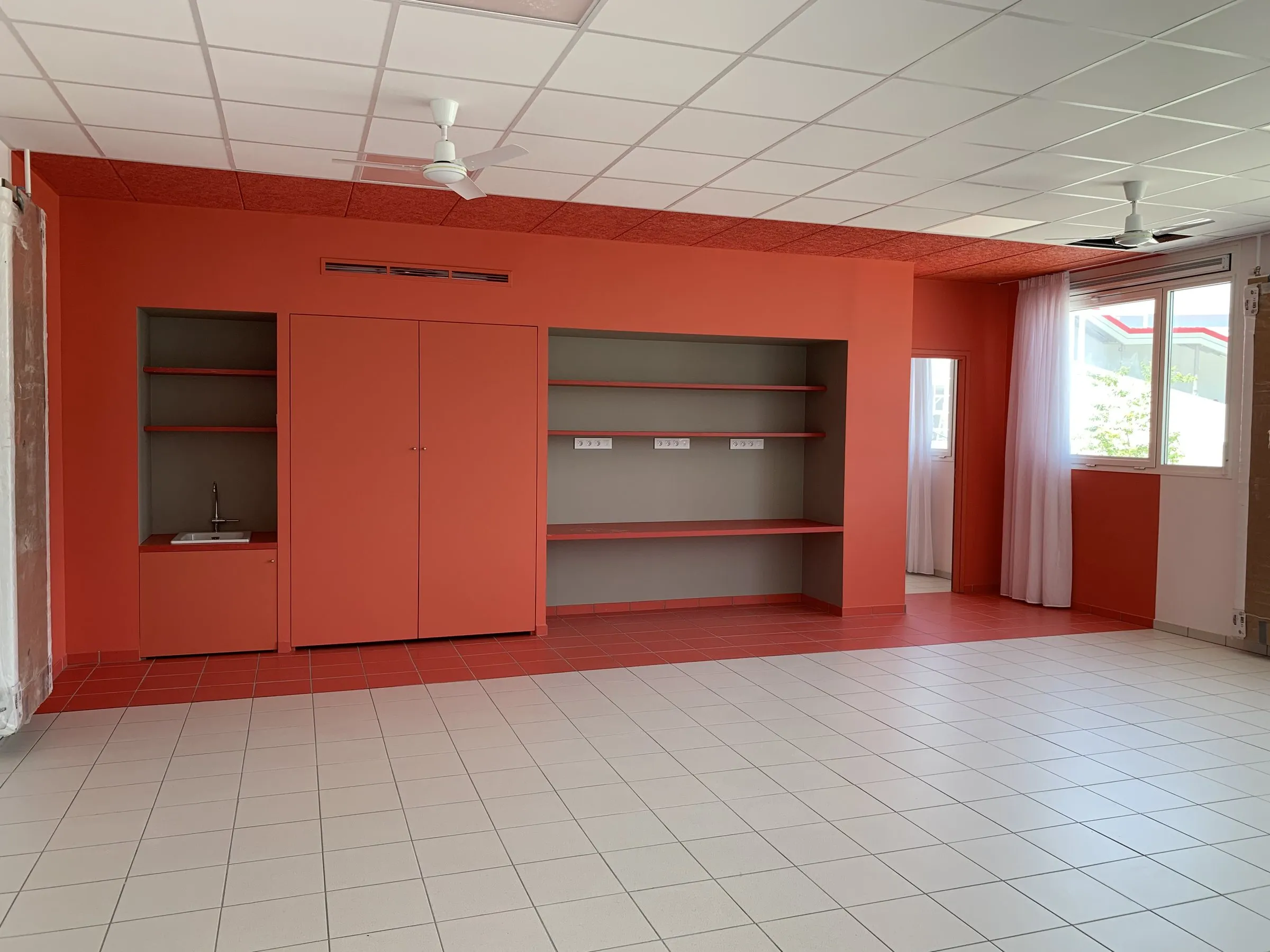 Mur corail de placards et d'étagères ouvertes