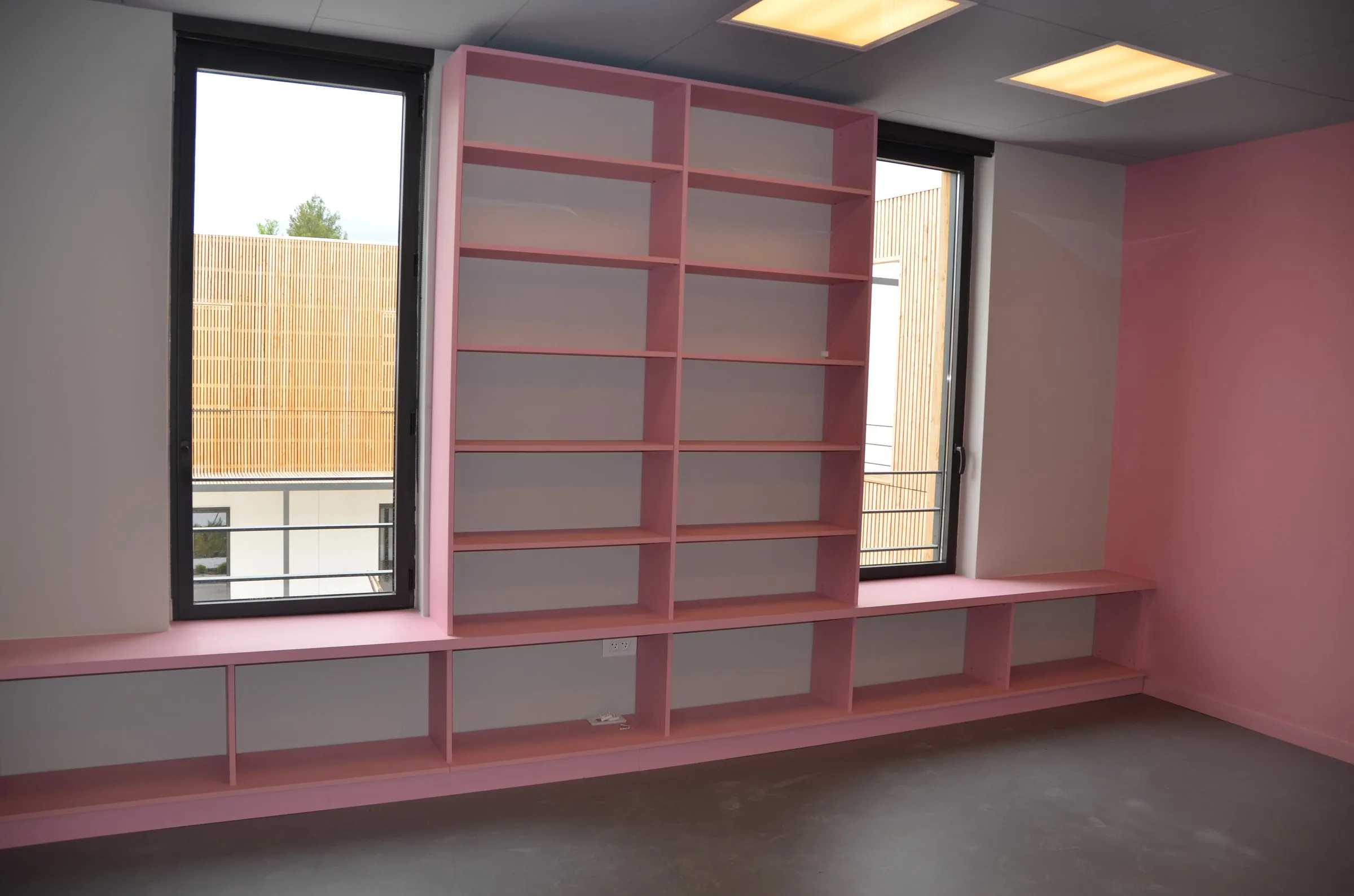 Bibliothèque rose et orange sur banc de fenêtre