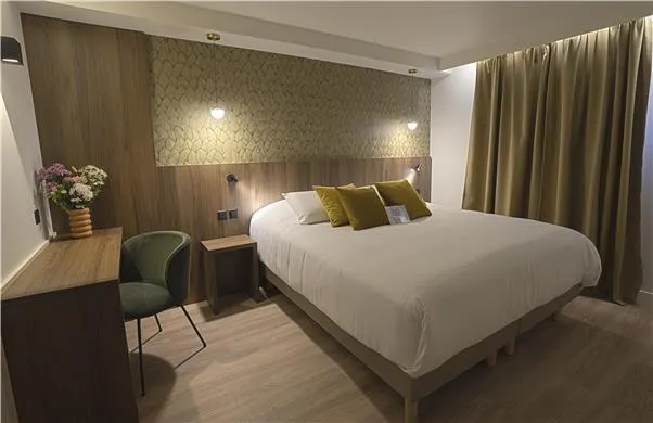 Chambre d'hôtel Kyriad : tête de lit et habillage mural en bois, chevets et commode sur mesure