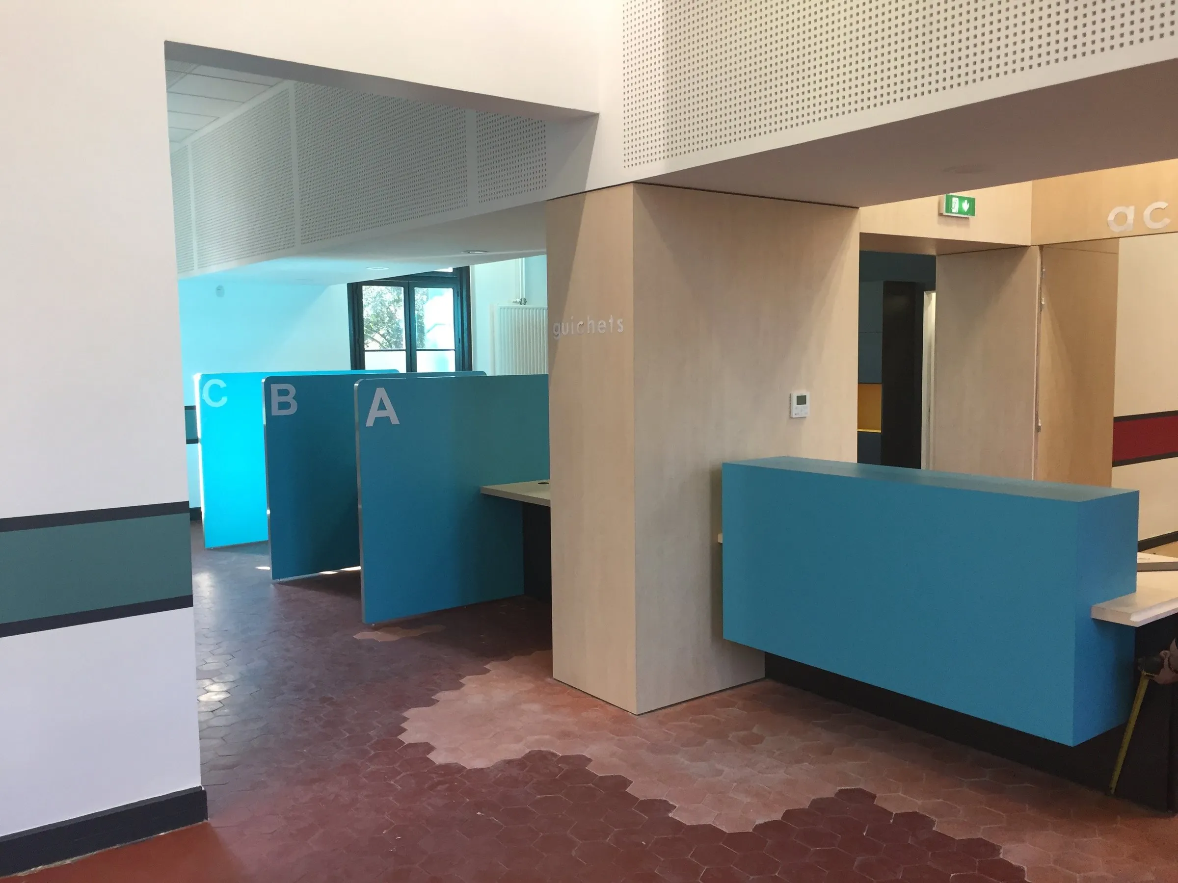 Banque et box d'accueil bleus, vue de l'entrée