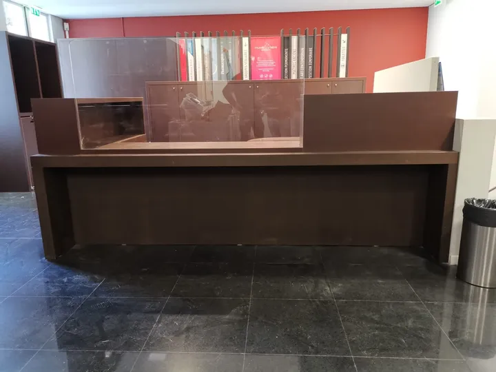 Banque d'accueil en bois sombre et plateau de verre, musée à Montpellier