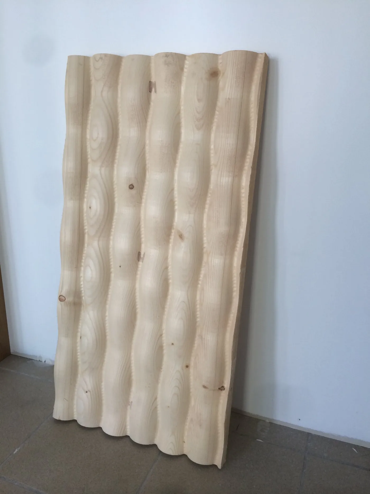 Panneau de bois massif sculpté en vagues, sorti de notre atelier