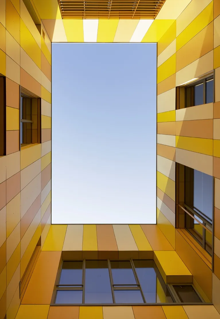 Vue vers le ciel depuis le fond du patio, panneaux jaunes et orangés