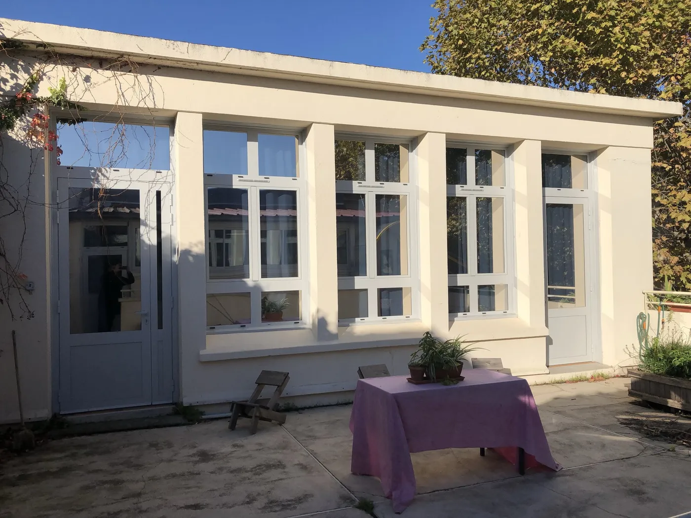Façade sur cour, fenêtres à impostes et portes vitrées blanches