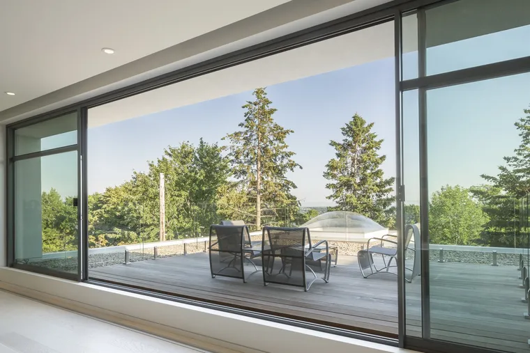 Baie coulissante aluminium toute hauteur ouverte sur une terrasse