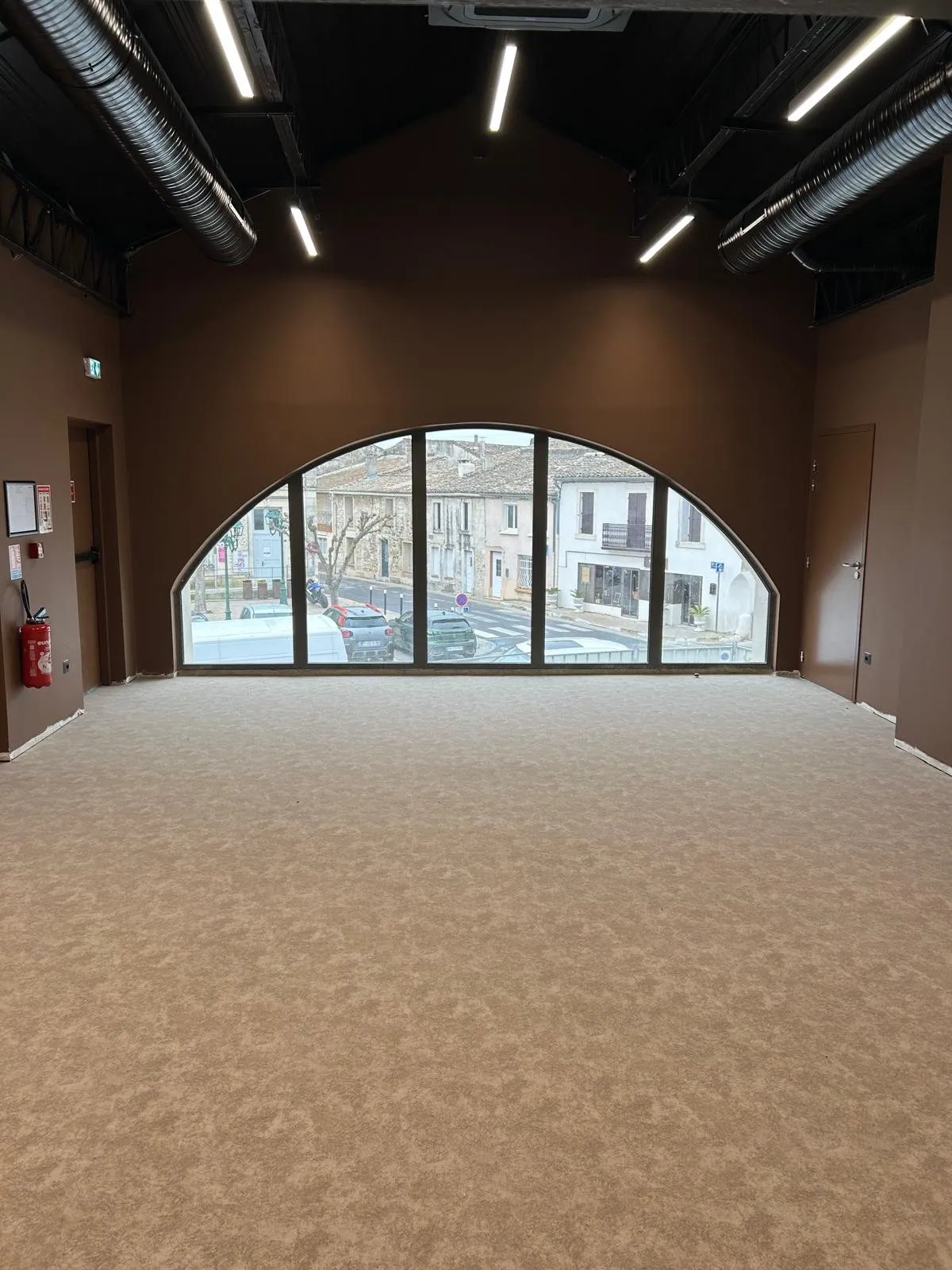 Salle de l'étage derrière le grand arc vitré, vue sur la rue