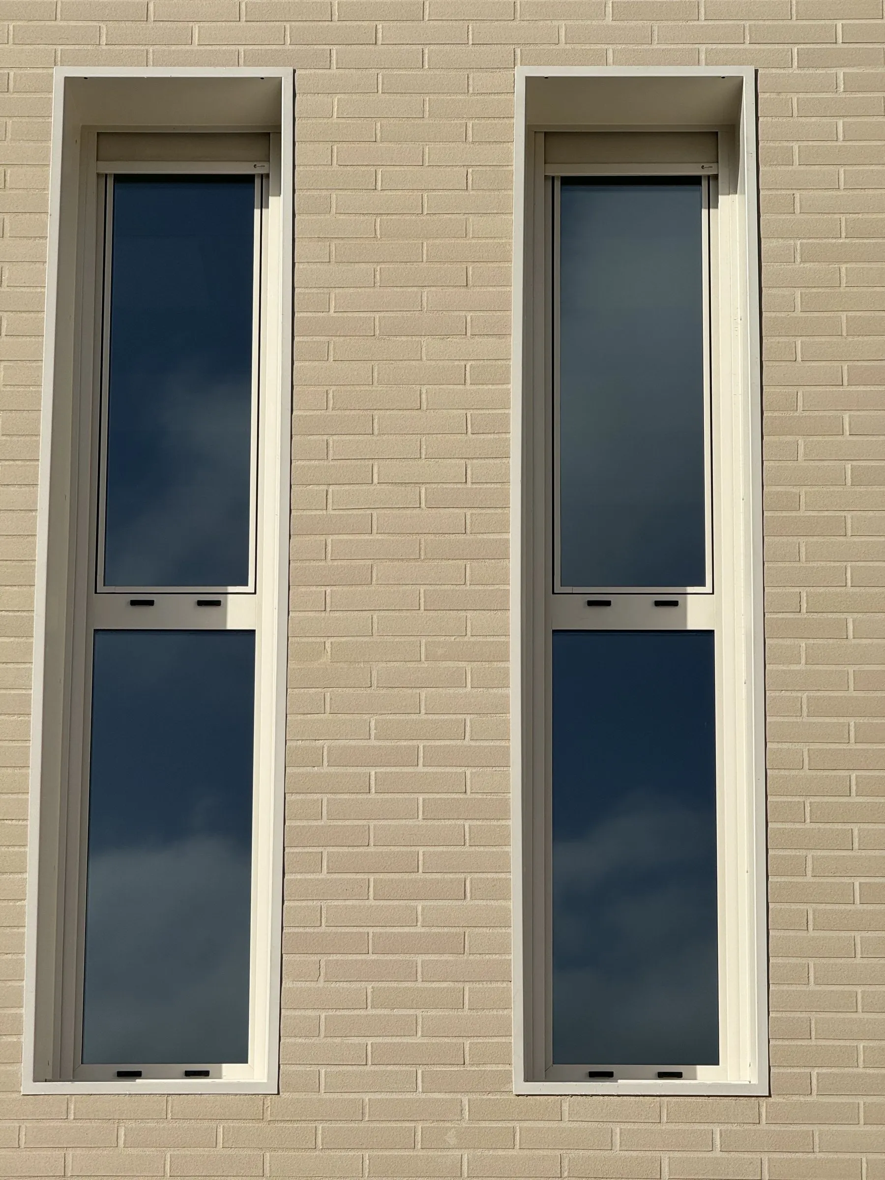 Fenêtres étroites à soubassement fixe dans la façade en briques