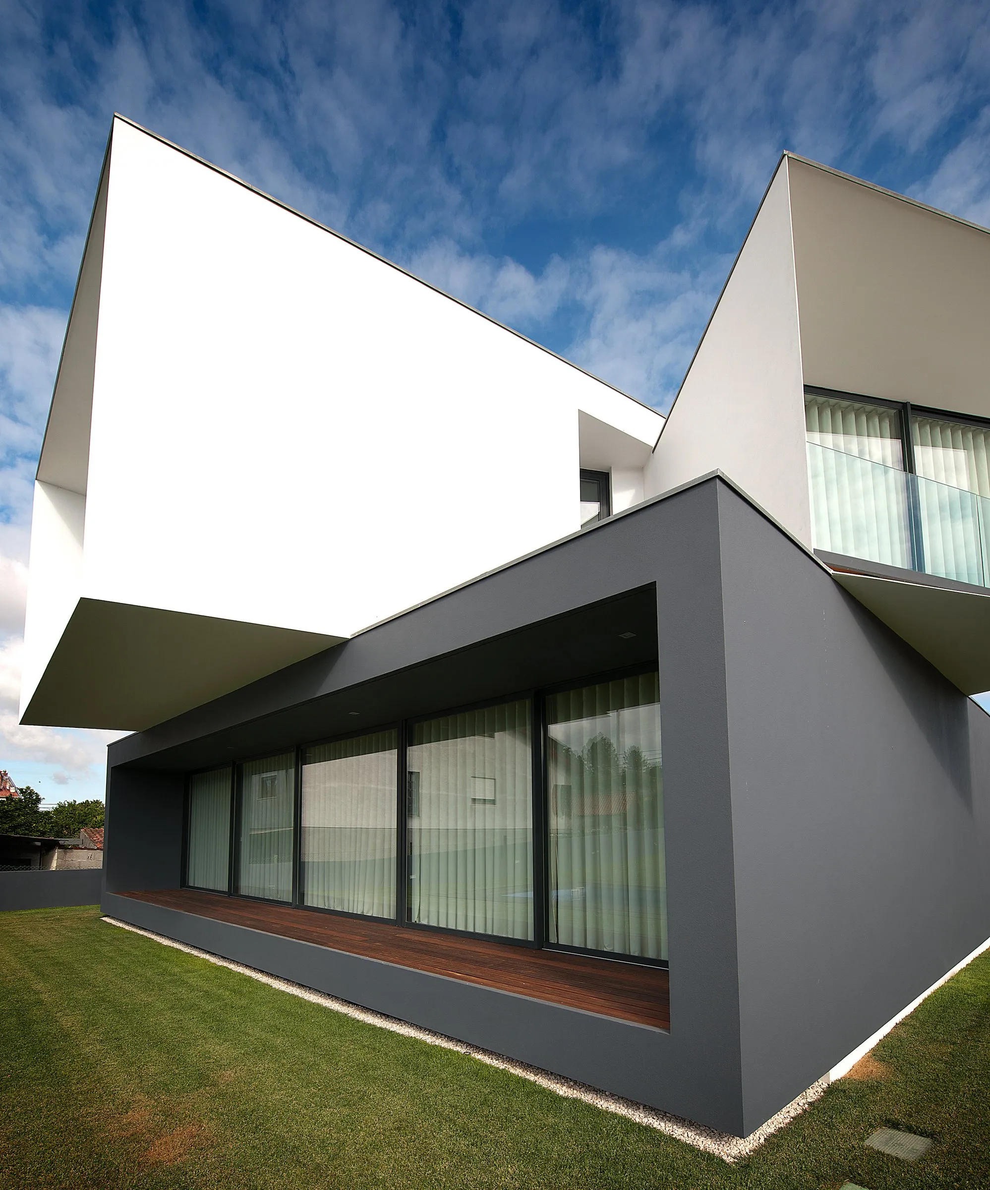 Volume sombre en porte-à-faux et bandeau de baies aluminium