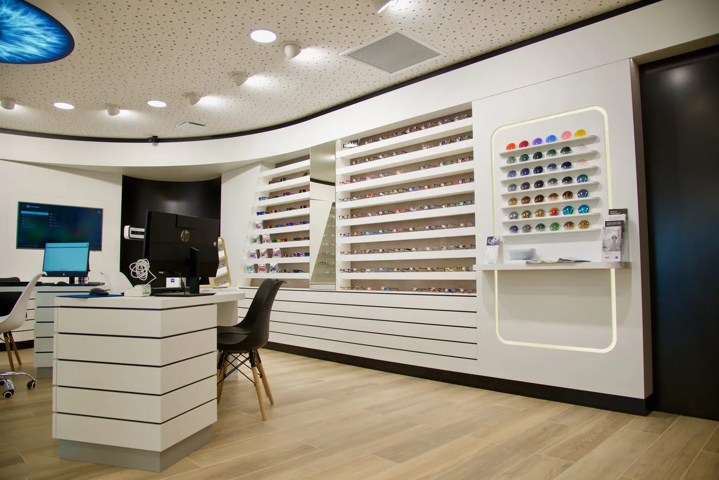 Boutique d'optique, comptoir à lamelles et murs de présentoirs sur mesure