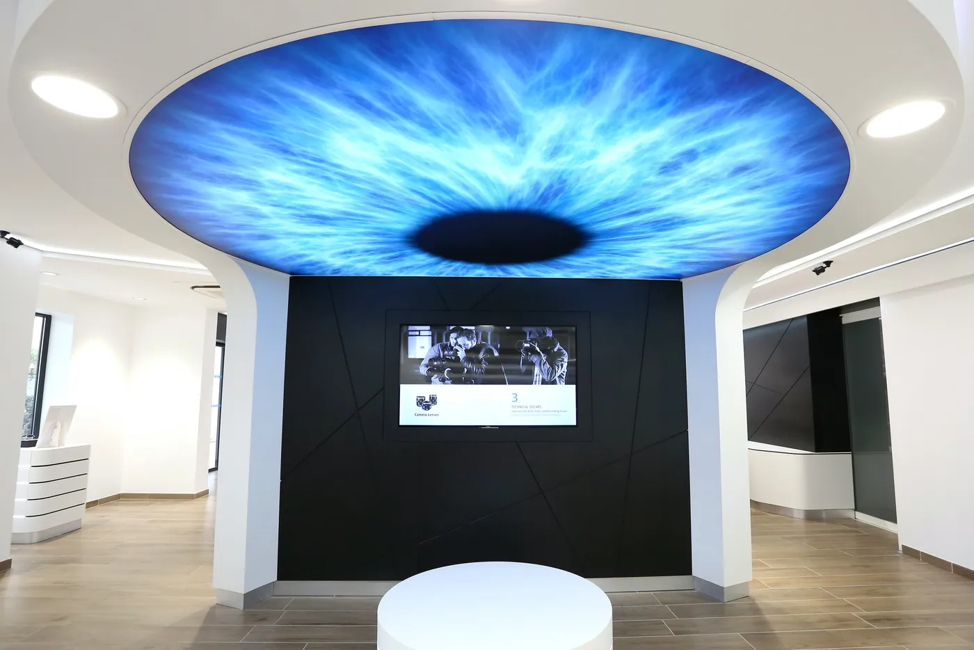 Plafond lumineux en forme d'iris sur mur noir, magasin d'optique à Montpellier