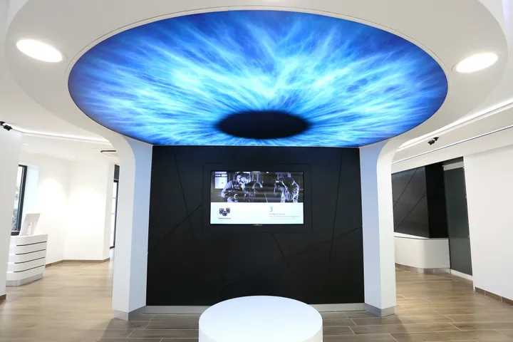 Plafond lumineux en forme d'iris sur mur noir, magasin d'optique à Montpellier